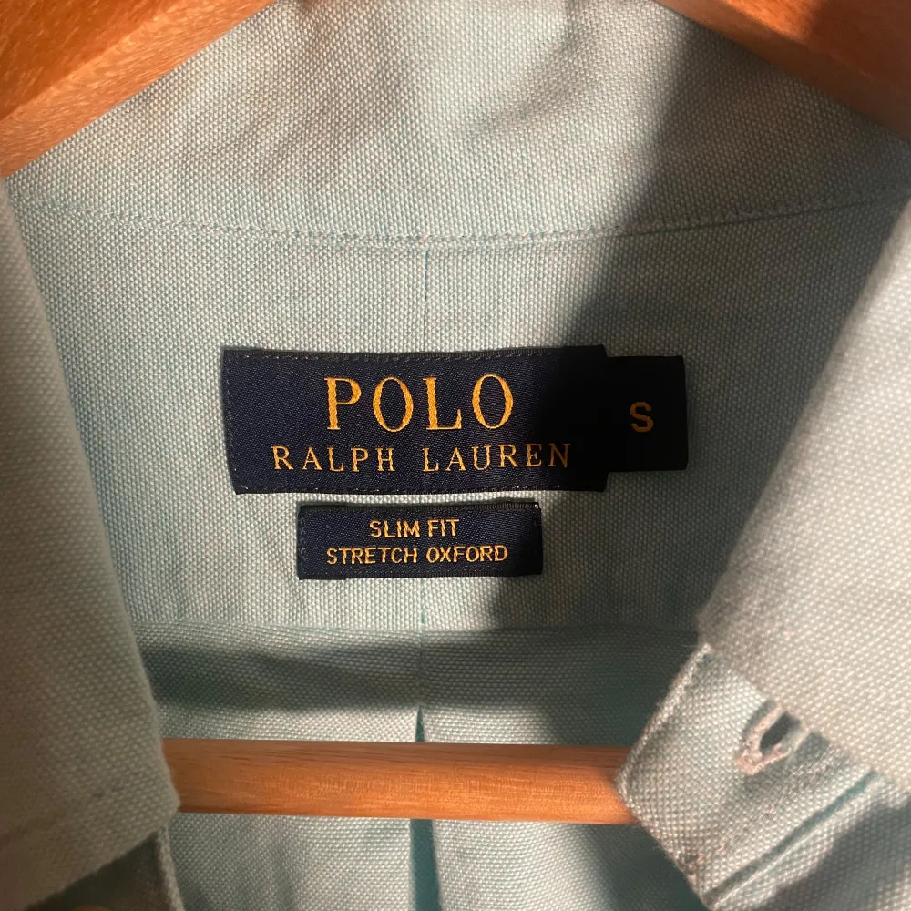 Säljer en stilren ljusblå skjorta från Ralph Lauren i slim fit. Skjortan är i stretchigt oxfordmaterial och har långa ärmar med knappar. Perfekt för både vardag och fest! . Skjortor.