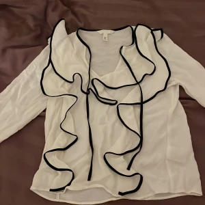 Volangblus  - En fin och stilig blus från hm som man kan knyta i storlek XS, men blusen är större i storlek så passar för S. Jag har använt blusen vid 1 tillfälle innan så den är i gott skick!