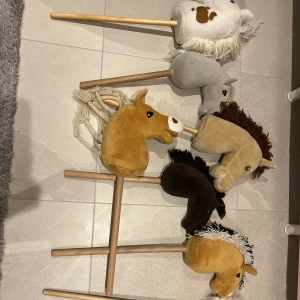 Käpphästar  - Käpphästar till salu från hööks och panduro.   BILD 1: Den grå och bruna kostar 150 kr st. Fjordingen och den beiga kostar 225 kr st. Vit och brun fläckiga och den beige med brun man kostar 250 kr st. Bild 4 och 5 kostar 50 kr st. BILD 2: Röda grimman  kostar 75 kr, grimskaftet kostar 30 kr. Svarta huvan kostar 50 kr, svarta täcket kostar 100kr. Förbygeln eller martingalen kostar 80 kr. BILD 3: Tränset kostar 140 kr, täckena kostar 75 kr st, huvorna kostar 45 kr st. 