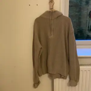 Säljer en snygg beige stickad tröja från Grunt i storlek M. Tröjan har en dragkedja vid halsen och långa ärmar, perfekt för kyliga dagar. Den är i bra skick och passar både till vardags och lite finare tillfällen. Nypris ca 750