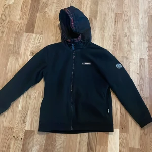 Svart hoodie från Plein Sport - Säljer en svart hoodie från Plein Sport i mycket bra skick. Den har en cool röd tigerdesign på ryggen och en dragkedja framtill. Perfekt för höst och vår, med en normal passform och långa ärmar. Huvan ger extra mysfaktor. Passar både till vardags och träning!     Nypris: 4500