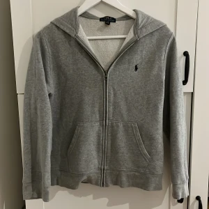 Ralph lauren zip hoodie - Säljer en fräsch ralph lauren zip hoodie som passar 14-15 åringar. Är i mycket fint skick. Nypris 1000kr.