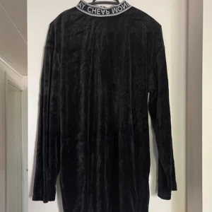 Svart sammet klänning - Säljer en elegant svart klänning i mjukt sammetstyg. Den har en långärmad design och är perfekt för höst och vinter. Klänningen är i nyskick och passar både till fest och vardag.