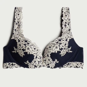 Intimissimi bh - Säljer en elegant mörkblå push-up bh med vackra vita spetsdetaljer. Den har en klassisk design med breda axelband och spets som sträcker sig över kuporna och axelbanden. köpte den runt maj-juni i år 💖💖💖