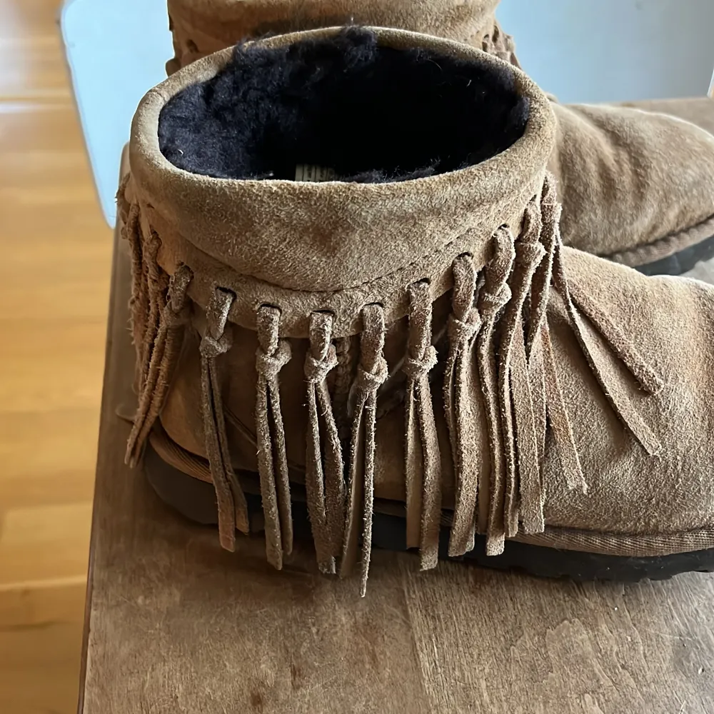 Så unika och coola Uggs med fransar från UGG australia, använda men i okej skick, kolla bild för att se fransar som lossnat, dock inget som märks om man har byxor över. Superfin färg perfekta till vintern! . Skor.