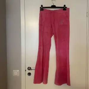 Säljer ett par snygga rosa byxor från Juicy Couture i storlek S men kan även passa dig som har M. Byxorna har en loose passform med bootcut-stil. Finns en söt detalj med en hund på ena fickan som har tyvärr  blivit förstörd. 