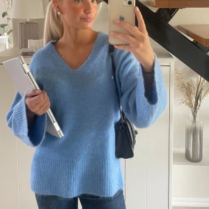 Stickad blå tröja - En jättefin stickad blå tröja med utsvängda armar 
