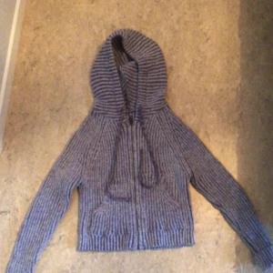 Grå ribbad hoodie - Säljer en supermysig grå ribbad hoodie. Perfekt för kyliga dagar med sin mjuka och varma känsla. Den har en dragkedja framtill och en stor huva som håller dig varm. Passar perfekt till både vardag och mysiga hemmakvällar.
