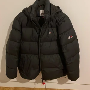 Tommy hilfiger jacka - Säljer en snygg och varm svart pufferjacka från Tommy Hilfiger. Jackan är nästan som ny då den har varit väl omhändertagen. Den är i storlek M och har inga defekter. Perfekt för både höst och vinter! Hör av er för mer info 😁