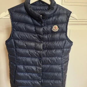 Blå Moncler Väst - Blå Moncler väst. Skick 9/10. Storlek 150 cm. Nypris ca 3000kr. Pris kan diskuteras.