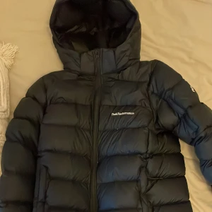 Svart dunjacka från Peak Performance - Säljer en svart dunjacka från Peak Performance i storlek 160.  Passar för både tjejer och killar och är i as bra skick, använd ca 3 gånger. Köpt för 3350 kr men säljer för 1800kr💕 köparen står för frakten !