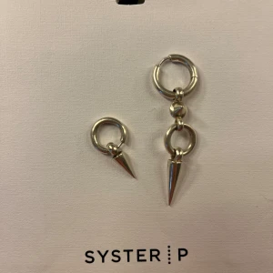 Juno örhänge - Syster P örhängen i bra skick, silver. Nypris lilla örhänget : 499 kr Nypris stora örhänget : 1199 kr Kan köpas tillsammans eller separat (350 kr lilla, 850 kr stora, 1200 kr tillsammans) De ser lite gula ut på bilden vilket de inte är egentligen 