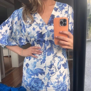 Broderad blommig klänning - Supersöt klänning i broderat tyg perfekt att ha med en stickad tröja över eller i sig själv!