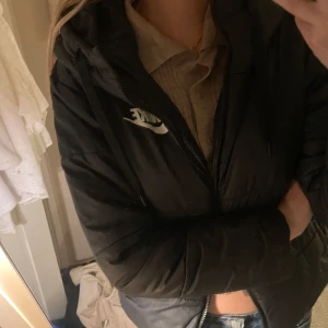 Dunjacka - En dunjacka man kan vända utochin för att få en större Nike logga i ryggen. Med luva och fickor i sidorna. Använd några gånger men inga skador. 
