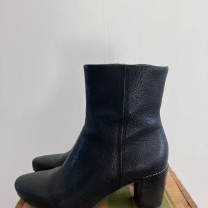 Clarks stövletter äkta läder - Clarks stövletter i äkta läder, 5cm klack, men har en liten gömd platå i råseglen så den upplevs mer som en 3-4 cm för fötterna. Använda 2 ggr