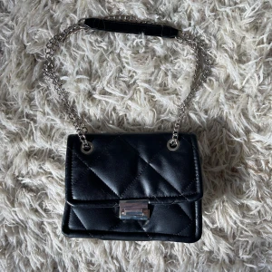 Svart kedjeväska - Köpt för ett tag sen på zalando, har tappat färgen på kedjen vid några ställen (finns bild). Skriv om du har fler funderingar💛