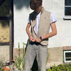Beige Morris väst - Exklusiv beige dunväst från Morris Stockholm. Perfekt för höst och vår. Västen är över lag i bra skick, utöver ett minimalt hål i vänster ficka, syns inte utvändigt❌Nypris 2500kr😸Knappast använd!