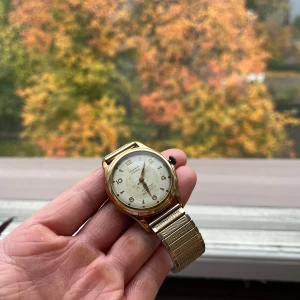 Lagonda vintage klocka  - Säljer ett mekanisk urval Lagonda 17 jewels med champagnefärgad boett och créme brulée patinerad urtavla. Klockan är 35mm och tickar på fint. Med tillkommer ett guldfärgat flexiarmband. Se bilder. 