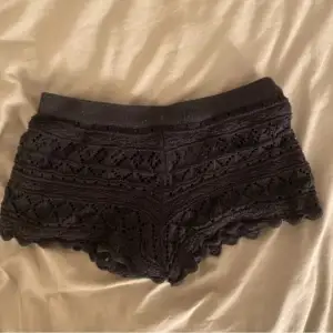 Säljer ett par svarta shorts i spets från H&M Divided. De är i storlek XS och har en snygg och detaljerad spetsdesign. Perfekta för sommarens alla tillfällen! 🖤