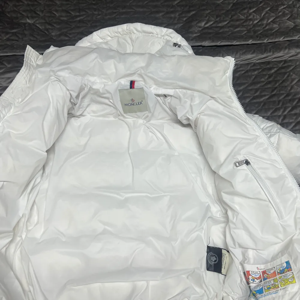 Säljer en snygg vit dunjacka från Moncler i mycket bra skick. Jackan har en dragkedja framtill och en mysig huva för extra värme. Perfekt för kalla vinterdagar! Den är quiltad och har en stilren design som passar till det mesta. 👍. Takit.