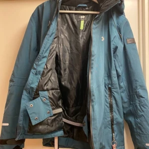 Billig varm vinterjacka / skidjacka, grön, storlek MEDIUM - FYNDA! Jättefin skidjacka, använd två vintrar, fodrad, snölås, liftkortsficka, avtagbar huva. Från lager 157. Medium. Skickas mot porto eller hämtas i Lund.