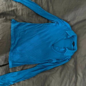 Blå ribbad tröja - Säljer en snygg blå ribbad tröja med lång ärm och v-ringad krage. Perfekt för både vardag och festliga tillfällen. Tröjan är i bra skick och passar perfekt till jeans eller kjol. Skön och stretchig för en bekväm passform. Hör av dig vid intresse! 💙