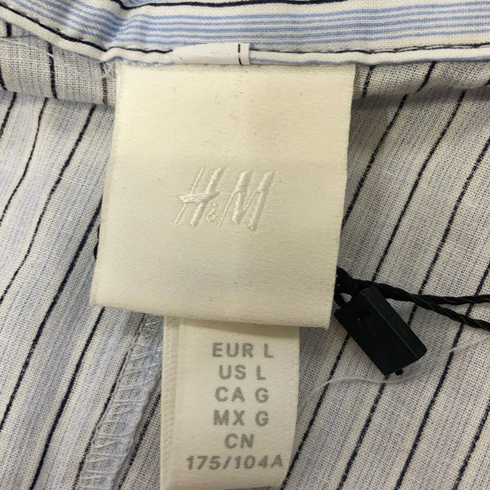 Säljer en stilren och bekväm randig klänning från H&M i storlek L. Klänningen är ärmlös och har en lång design med knappar framtill. Tillverkad av 100% bomull, vilket gör den perfekt för varma dagar. Passar både till vardags och sommarens festligheter!. Mekot.