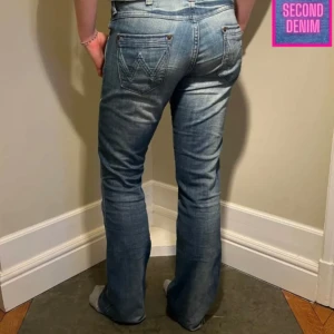 Lågmidjade jeans - Lågmidjade bootcut jeans från wrangler med rå kant. Midjemått 88cm. Innerbenslängd 84cm. Hon på bilden är 170cm💗