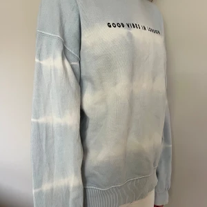 Ljusblå sweatshirt från Zara - Säljer en superfin ljusblå sweatshirt från Zara med texten 'Good Vibes in London, UK' på bröstet. Tröjan har ett batikmönster i vitt. Skriv för fler bilder eller frågor!