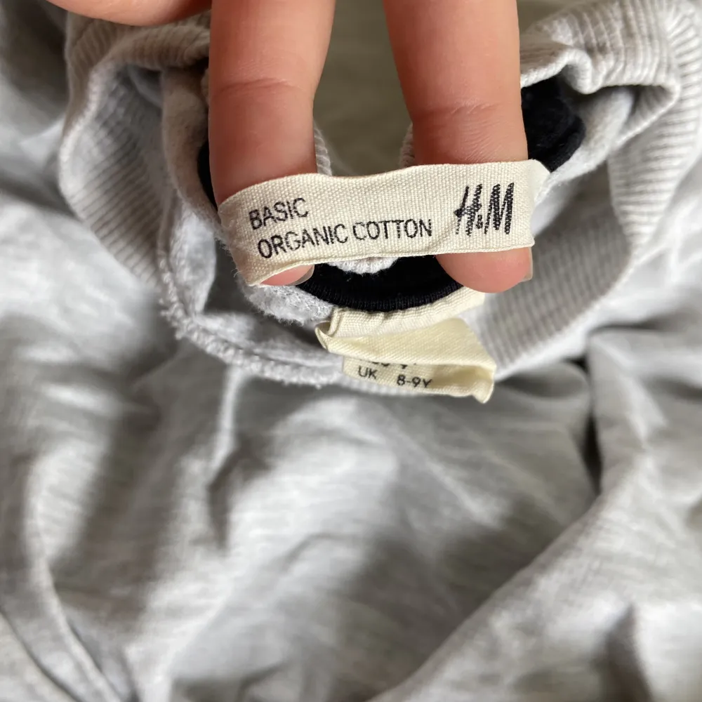 Säljer en grå långärmad tröja från H&M i storlek 134. Tröjan är tillverkad av ekologisk bomull och är supermjuk och bekväm. Perfekt för vardagsbruk och passar bra till både jeans och leggings. Den är i bra skick och redo för en ny ägare!. Tröjor & Koftor.