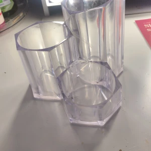 Transparenta plastbehållare - Säljer tre transparenta plastbehållare som är sammanfogade. Perfekta för att organisera pennor, penslar eller andra småsaker på skrivbordet. Behållarna har en hexagonal form och är tillverkade av hållbar plast. De är lätta att rengöra och passar bra i alla typer av rum.