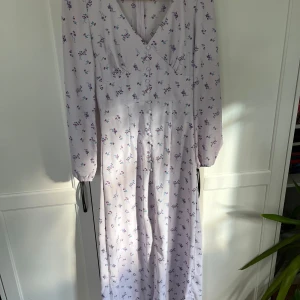Blommig klänning  - Står att det är storlek 36, som jag har, men är liten i storlek så skulle säga 34 ändå. Kedja i bak och knapparna går inte att öppna eller stänga, lång slits i fram. Jätte fin men som sagt för liten❣️