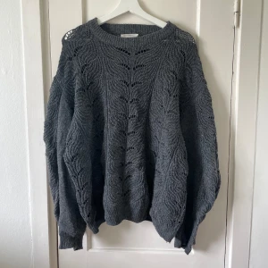 Grå stickad tröja från Angelology - Säljer en supermysig grå stickad tröja från Angelology i storlek XL. Tröjan har ett fint mönster och är perfekt för höst och vinter. Den är långärmad och har en lös passform som gör den extra bekväm. 💙