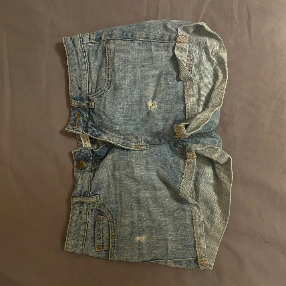 Säljer ett par snygga jeansshorts från Detroit by Limex. De är i en klassisk blå jeansfärg och har en sliten look med små revor. Perfekta för sommaren! ❤️. Shorts.