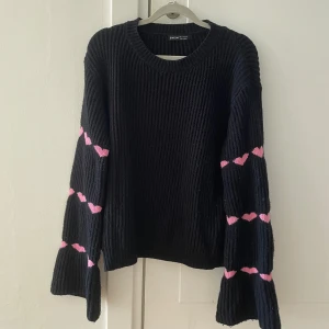 Svart stickad tröja från Shein - Såå fin svart stickad tröja från Shein i storlek S. Tröjan har långa ärmar med söta rosa hjärtan som detaljer. Sparsamt använd. Passar även M. 