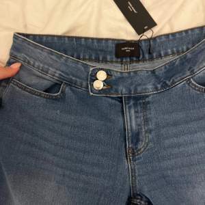 Låg midjade jeans från Vero Moda med ”sido knäppning”. Helt nya aldrig använda med prislappen kvar. Storlek XL men små i passform. Skriv för fler bilder!!