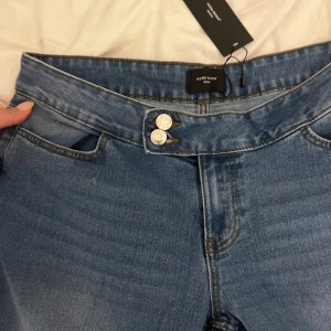 Low waist jeans - Låg midjade jeans från Vero Moda med ”sido knäppning”. Helt nya aldrig använda med prislappen kvar. Storlek XL men små i passform. Skriv för fler bilder!!