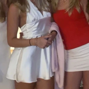 Satinklänning - Jättefin satin klänning med volang och rosett där bak som passar jättebra till fest, student eller liknande. Den har lite slitningar men man ser inte när den är på men därav priset🥰