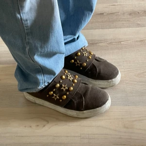 Sneakers  - Bruna mocka sneakers, kardborrband med guldiga stjärnor och nitar. Inte helt nytt skick men sulorna kan man göra rent😜