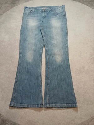 lågmidjade ljusblå bootcut jeans - Snygga lågmidjade ljusblå bootcut jeans. Jeansen har en lätt utsvängd passform och är tillverkade i ett mjukt denimtyg.