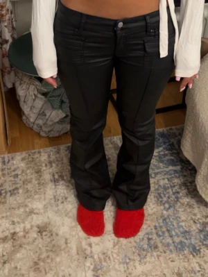 Svarta bootcut jeans med fickor - Säljer ett par svarta bootcut jeans med fickor fram och bak från Nelly. Jeansen har en låg midja och stängs med knapp och dragkedja. Materialet är stretchigt och ger en snygg passform. Perfekta till en trendig vardagslook.