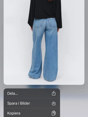 Ljusblå high waist bootcut jeans - Säljer ett par ljusblå jeans med hög midja och bootcut passform. Jeansen har slitna detaljer på båda benen framtill och klassiska fem fickor. Tillverkade i bomull med en skön jeanskänsla. Perfekta för en avslappnad och trendig look.