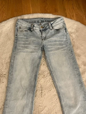 Ljusblå jeans bootcut, Cheap Monday  - Snygga ljusblå jeans med bootcut och diskreta slitningar. Modell Bootybei. Blåa ronder i rumpan är tygets mönster. 