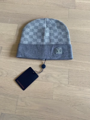 En rutig grå mössa. - Säljer en grå rutig mössa. Helt ny. Oanvänd. Passar både tjejer och killar.