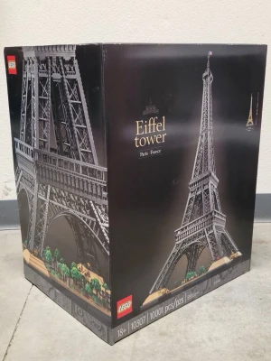  Eiffel Tower 10307 byggsats - Säljer en  byggsats av Eiffeltornet, modell 10307. Setet innehåller 10001 bitar och är en detaljerad modell av Eiffeltornet i Paris. Förpackningen är svart med en bild på det färdiga tornet och rekommenderas för personer över 18 år.