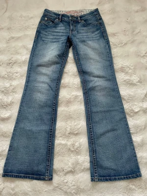 Blå bootcut jeans med broderade fickor - Snygga blå bootcut jeans med broderade detaljer på bakfickorna. Klassisk femficksmodell med normal passform och låg midja. Passar bra i längd på mig som är 166 cm 🩷