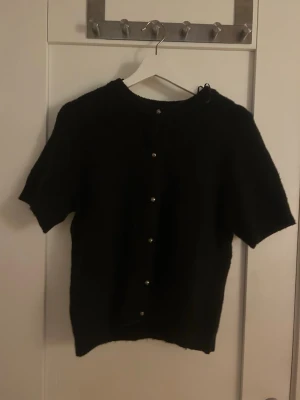Stickad tröja från gina med silver knappar  - Söt svart stickad tröja från gina med silverknappar. Är i storlek M. Har aldrig använt. 