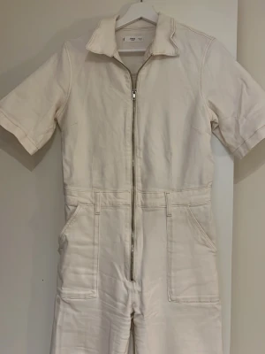 Vit/beige denim-jumpsuit - L - Vit/beige denim-jumpsuit från Mango, storlek L men mer som en M. I nyskick