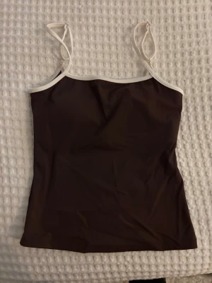 Brun linnetopp från exercere - Supersnygg träningstopp från exercere. Den att inlägg som är avtagbara och reglerbara axelband! 