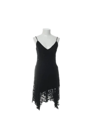 Svart spetsklänning Polo Ralph Lauren - Svart klänning från Polo Ralph Lauren med smala axelband och v-ringning. Klänningen har ett lager av blommig spets och asymmetrisk nederkant som ger en cool look. Perfekt för dig som gillar stilrena och eleganta plagg.    Se bilder för skick och eventuella fläckar eller slitningar.  Rökfritt och djurfritt hem!